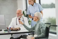 Una médica conversando con un paciente en una clínica luminosa
