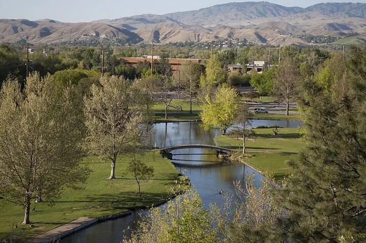 Estanques y puentes peatonales en Ann Morrison Park, con las colinas de Boise al fondo